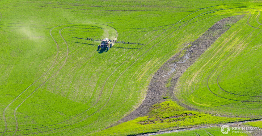 Tractor spraying crops in the Palouse