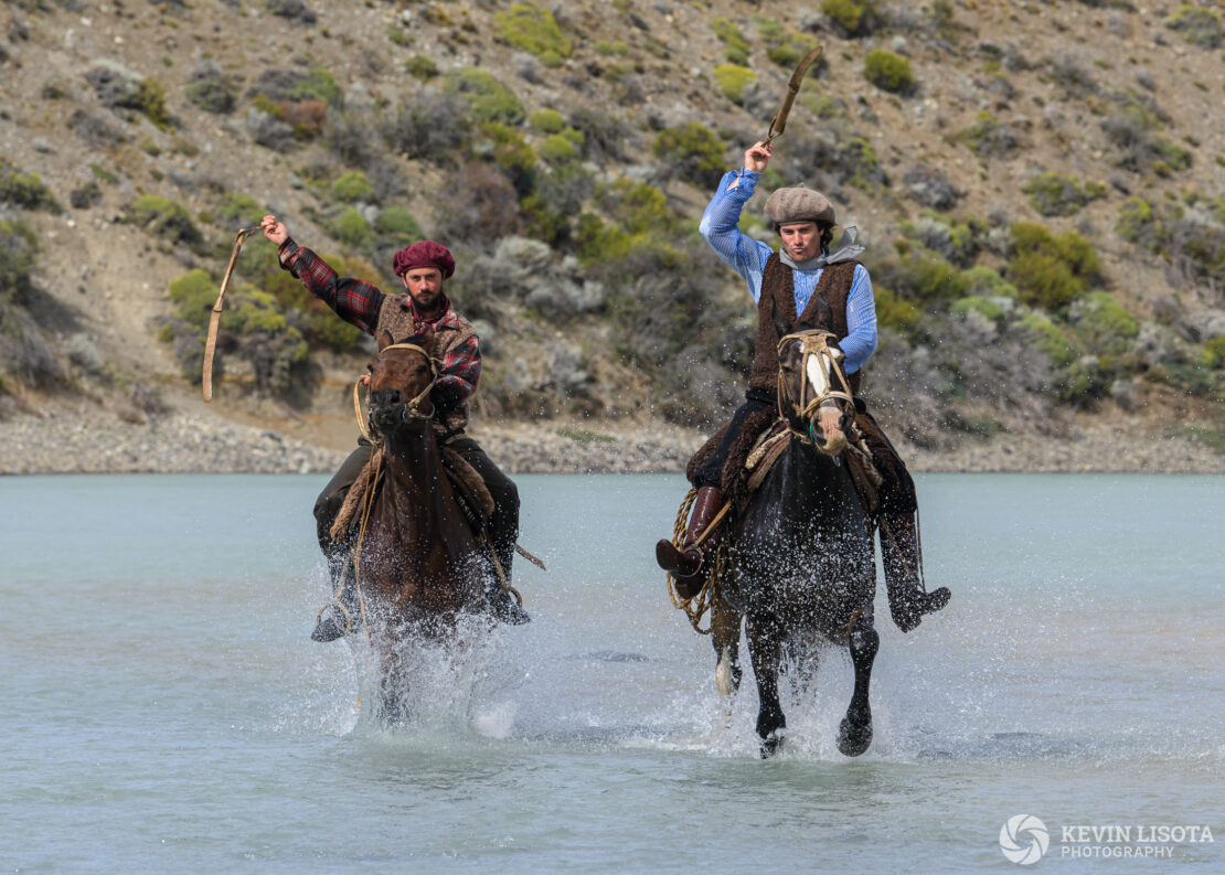 Gauchos on horseback in the La Leona River of Patagonia