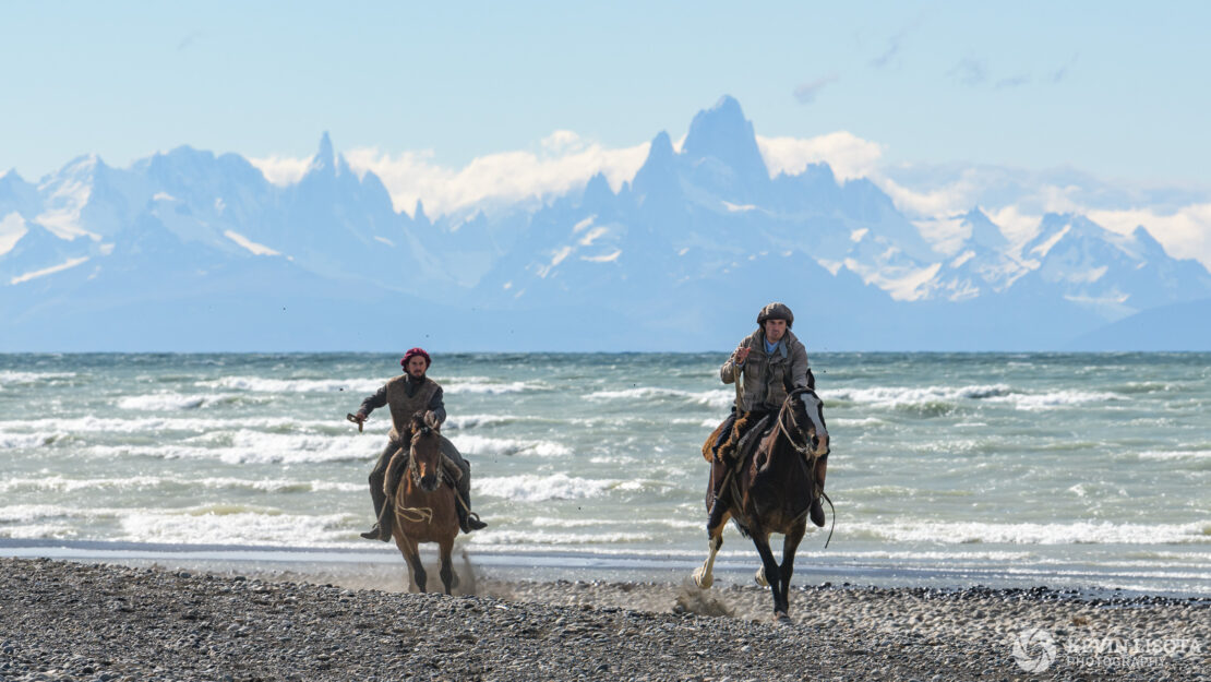 Gauchos gallop on the shore of Lake Viedma