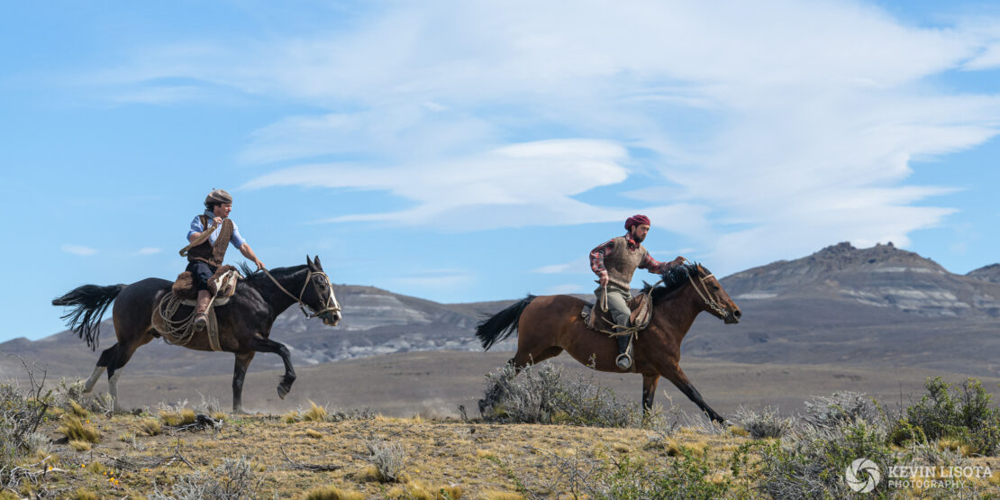 Gauchos gallop across the Patagonia plains on horseback