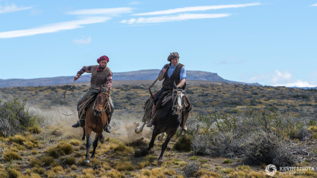 Gauchos gallop on horseback in Patagonia